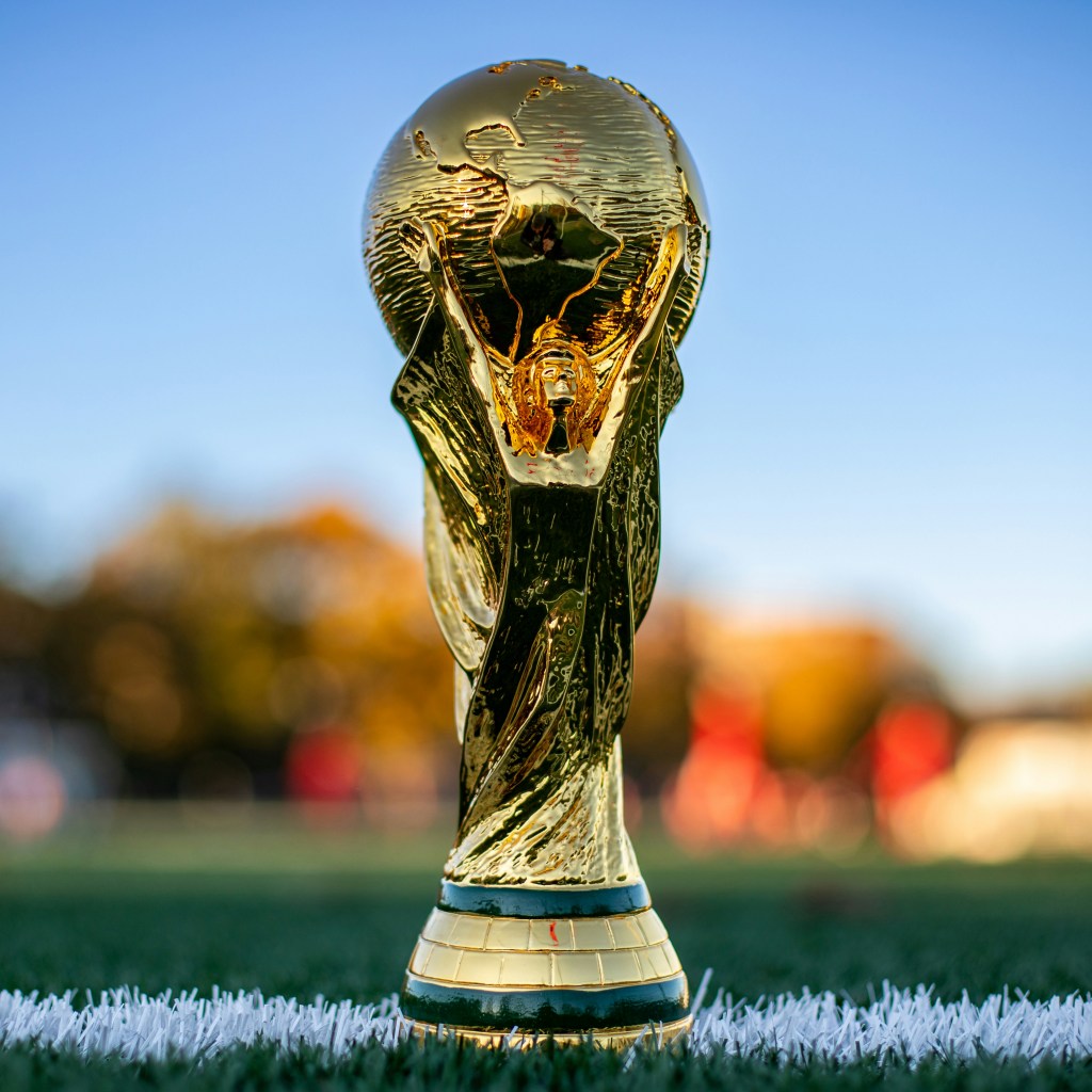 World Cup trophy sitting on a soccer field.